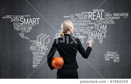 Businesswoman standing near world map on wall Businesswoman standing near world map on wall 67668209