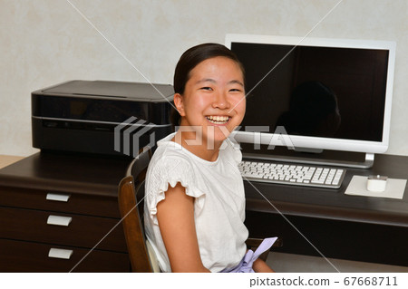 一個坐在電腦桌旁的女孩 67668711