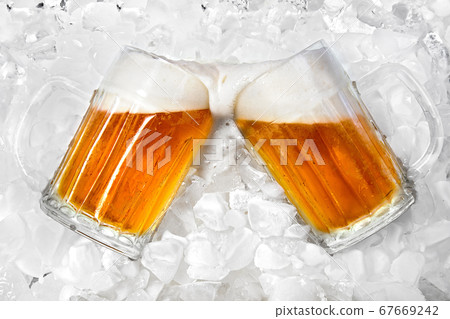 Glass of cold beer lying in the ice 67669242