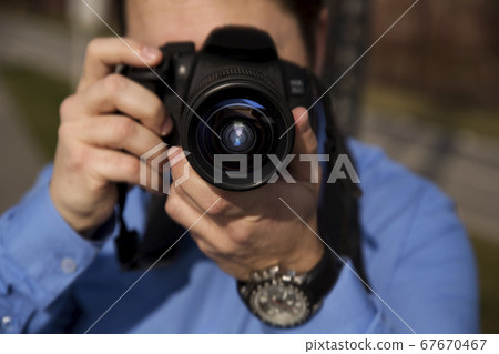 Photographer photographing outdoors. Shooting in 67670467