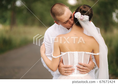 Portrait of groom and bride in their wedding day. Summer wedding Portrait of groom and bride in their wedding day. Summer wedding 67671424