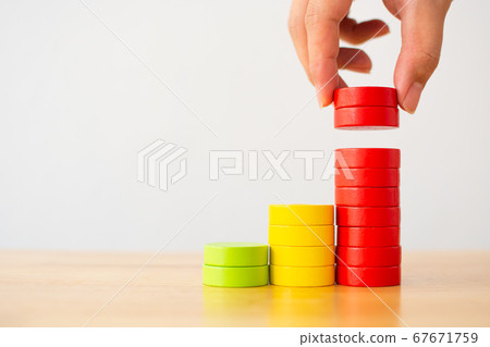 Hand arranging wood block multicolor stacking step as staircase on wooden table Hand arranging wood block multicolor stacking step as staircase on wooden table 67671759