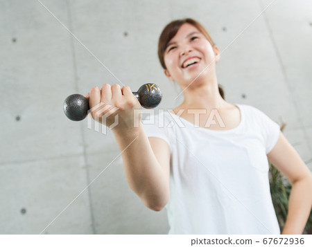 Japanese woman doing dumbbell training at home 67672936