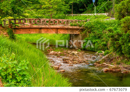 Bridge and river illuminated by countryside sunset 67673079