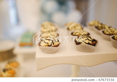 Candy bar on table in restaurant. Sweet desserts with blueberry on white table Candy bar on table in restaurant. Sweet desserts with blueberry on white table 67673538