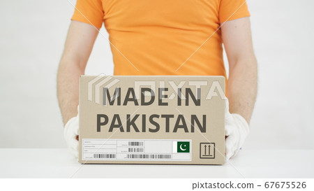 Carton with MADE IN PAKISTAN text being placed on the table Carton with MADE IN PAKISTAN text being placed on the table 67675526