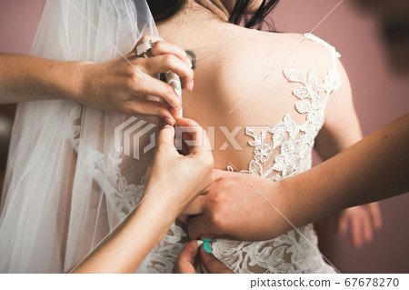 Beautiful bride wearing fashion wedding dress with feathers with luxury delight make-up and hairstyle, studio indoor photo shoot Beautiful bride wearing fashion wedding dress with feathers with luxury delight make-up and hairstyle, studio indoor photo shoot 67678270