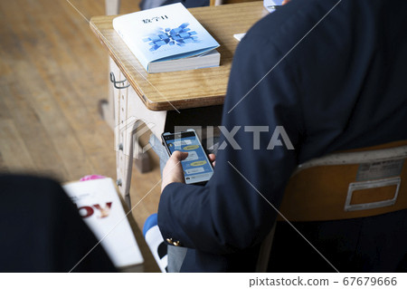 Students watching smartphones in class 67679666