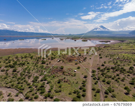 Aerial view of Maasai boma or family rural village on the coast of Salty lake Natron in the Great Rift Valley, Tanzania 67679869