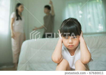 A sad child who doesn't want to hear the voice of his parents arguing 67680011