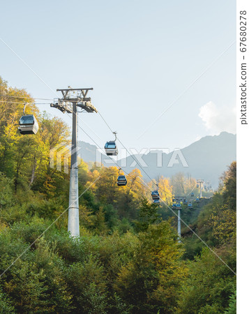 Passenger cabins move along cables of funicular. Cable road at Rosa Khutor Alpine Ski Resort. Sochi, Russia. 67680278