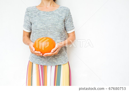 Women with pumpkin in hands. Autumn Halloween or Thansgiving concept 67680753