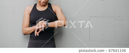 Healthy lifestyle and sport. Woman is happy with result of jogging and looks at fitness tracker Healthy lifestyle and sport. Woman is happy with result of jogging and looks at fitness tracker 67681106