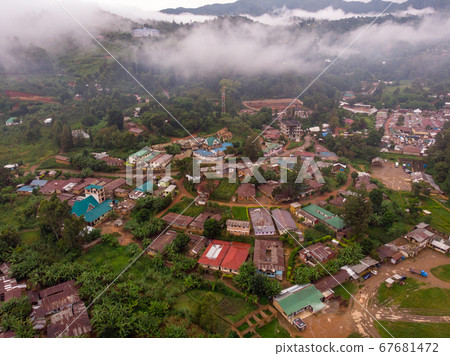 Aerial Drone Shot Flying by Cloudy Misty Foggy Lushoto village in Usambara Mountains. Remote Place in Tanga Province, Tanzania, Africa 67681472