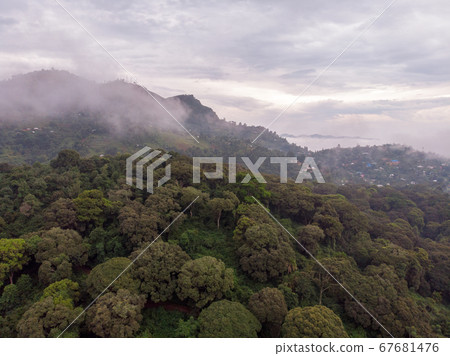 Aerial Drone Shot Flying by Cloudy Misty Foggy Lushoto village in Usambara Mountains. Remote Place in Tanga Province, Tanzania, Africa Aerial Drone Shot Flying by Cloudy Misty Foggy Lushoto village in Usambara Mountains. Remote Place in Tanga Province, Tanzania, Africa 67681476