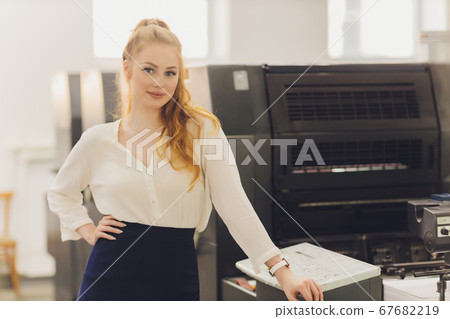 Young woman working in printing factory. Printing Press. Young woman working in printing factory. Printing Press. 67682219