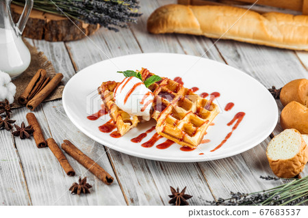Belgian waffles poured with ice cream berry syrup 67683537