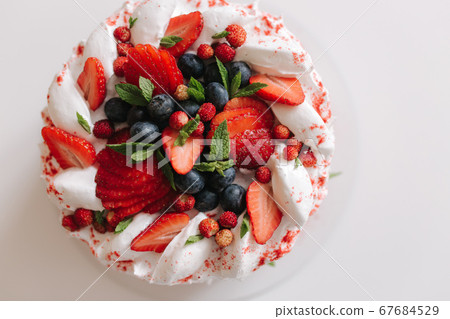 No bake strawberry cheesecake, decorated with sresh strawerries, mint and blueberry. Vegetarian food. Lactose free and gluten free. Top view 67684529