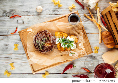 Ribeye steak with baked potatoes with sour cream 67685265