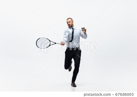 Time for movement. Man in office clothes plays tennis isolated on white studio background. 67686003