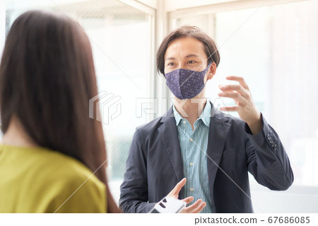 Men and women wearing masks and talking at work Men and women wearing masks and talking at work 67686085