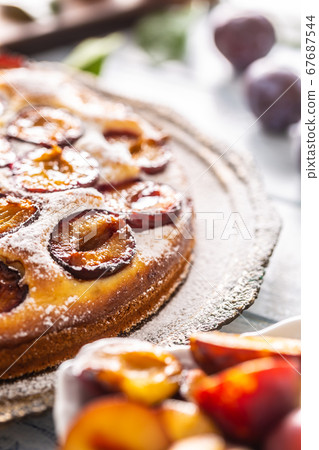 Homemade plum cake in vintage plate on wooden Homemade plum cake in vintage plate on wooden 67687544