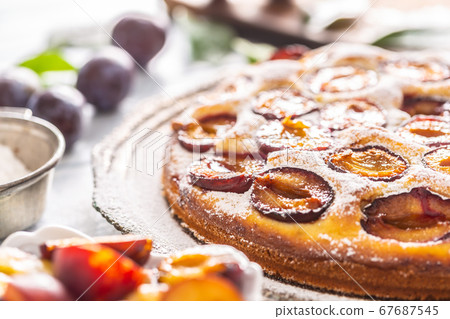 Homemade plum cake in vintage plate on wooden Homemade plum cake in vintage plate on wooden 67687545