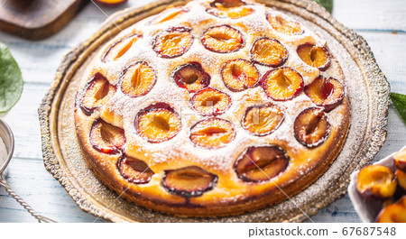 Homemade plum cake in vintage plate on wooden Homemade plum cake in vintage plate on wooden 67687548