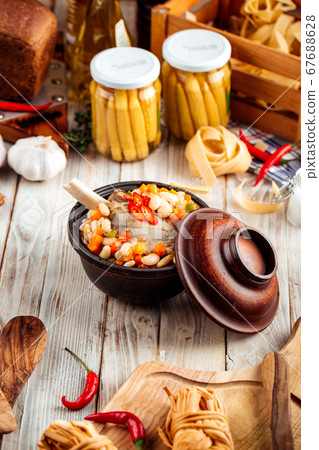 Stewed vegetables with beans and beef bone in pot 67688628