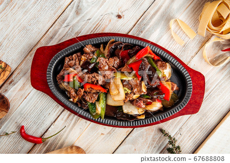 Beef in cast-iron pan with vegetables Beef in cast-iron pan with vegetables 67688808