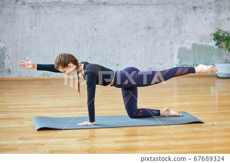Fit woman stretching in hall. Fit woman stretching in hall. 67689324