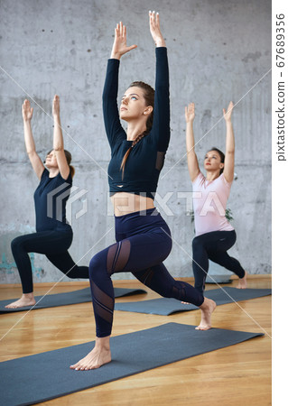 Group of women practicing stretching on mats. Group of women practicing stretching on mats. 67689356