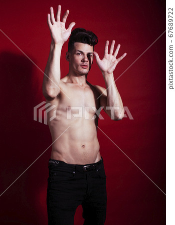 young fashion style man with naked torso dancing emotional posing on red background, lifestyle people concept young fashion style man with naked torso dancing emotional posing on red background, lifestyle people concept 67689722