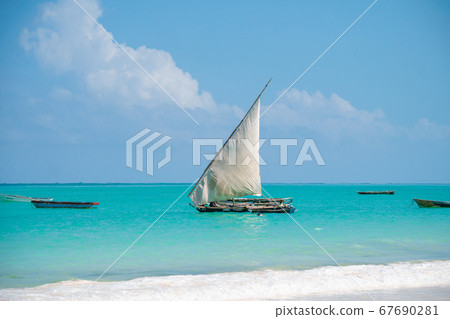 Wooden sailboat dhow on the clear turquoise water of Zanzibar island 67690281