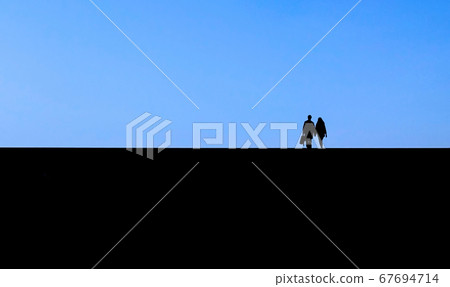 Photo of lovers taken against backlight against a blue sky 67694714