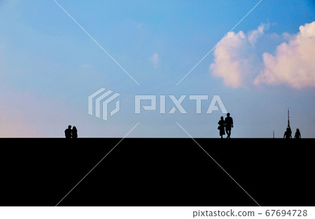 Photo of lovers taken against backlight against a blue sky 67694728
