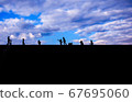 Children photographed in silhouette against a blue sky 67695060