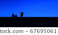 Children photographed in silhouette against a blue sky 67695061
