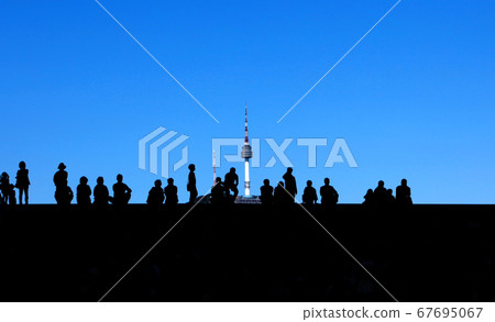 People photographed in silhouette against a blue sky People photographed in silhouette against a blue sky 67695067