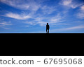 Man photographed in silhouette against a blue sky 67695068