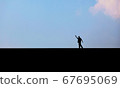 Man photographed in silhouette against a blue sky 67695069
