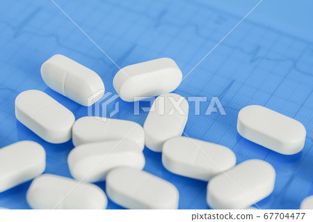 Background of white tablets or pills on the table. Background of white tablets or pills on the table. 67704477