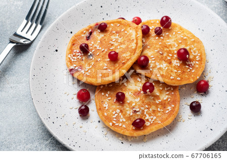 Pancakes with cottage cheese and cranberries. Homemade fried cheesecakes. Pancakes with cottage cheese and cranberries. Homemade fried cheesecakes. 67706165