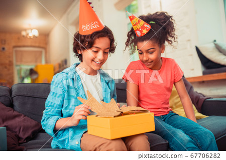 Smiling boy unwrapping his big birthday present 67706282