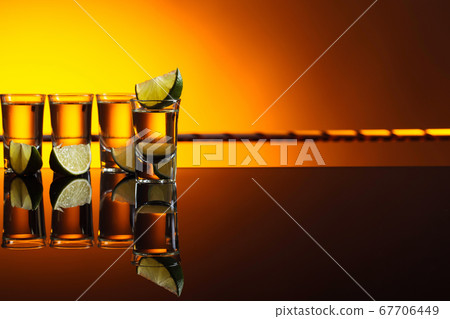 Gold Tequila in short glasses with lime on 67706449