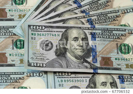 One hundred dollars. Benjamin Franklin. US dollars background. Closeup of a lot of banknotes hundred dollar bills. American currency. One hundred dollars. Benjamin Franklin. US dollars background. Closeup of a lot of banknotes hundred dollar bills. American currency. 67706532