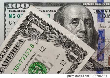 One hundred dollars and one dollar bills. Closeup of Benjamin Franklin and George Washington . US dollars background. American currency. 67706551
