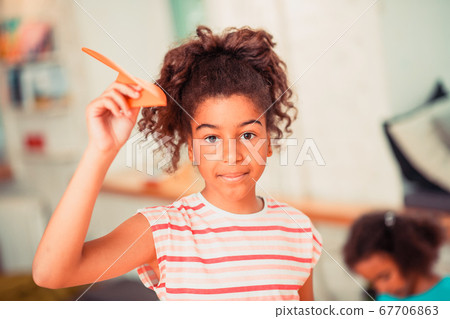 Little girl making an orange paper plane Little girl making an orange paper plane 67706863
