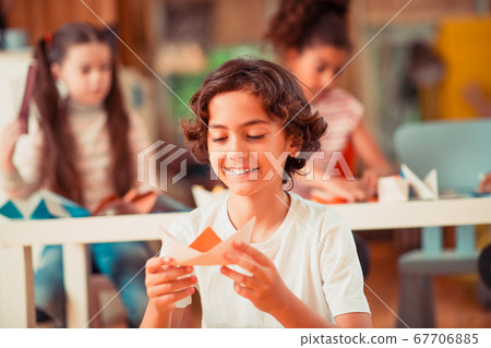 Smiling boy making a ship from a paper Smiling boy making a ship from a paper 67706885