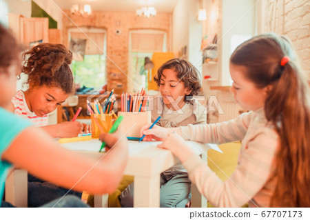 Group of children drawing with color pencils 67707173